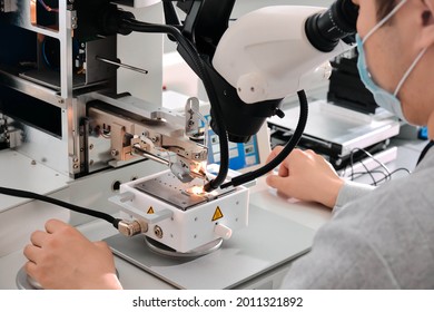 Electronics Engineering Scientist  Working With Microscope Looking At Silicon Micro Chip. Chemicals Researcher Investigating Micro Chip. Semiconductor Technological Manufacturing Process Control