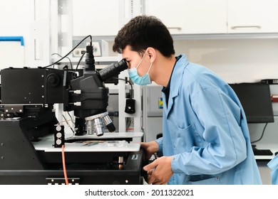 Electronics Engineering Scientist  Working With Microscope Looking At Silicon Micro Chip. Chemicals Researcher Investigating Micro Chip. Semiconductor Technological Manufacturing Process Control