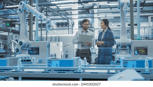 Electronics Factory Digitalization: Automated Robot Arm Assembly Line Manufacturing Equipment. Managers Discussing Work while Futuristic AI Computer Vision Analyzing, Scanning Production Line