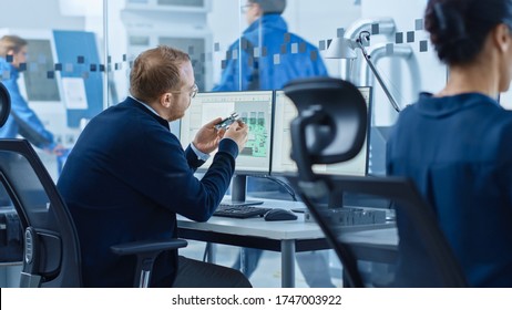 Electronics Factory: Male Electrical Engineer Holds PCB Prototype, Works On Computer, Uses CAD Software To Develop Microchips, Semiconductor And Telecommunications Equipment. Manufacturing Facility