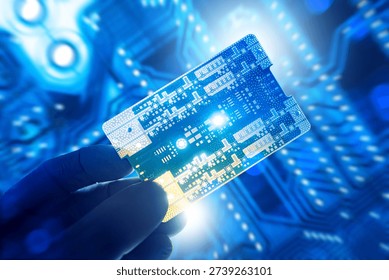 Electronics manufacturing, Microtechnology. Technician in gloves holds printed circuit board, inspecting components for quality control, testing, assembly and semiconductor production.