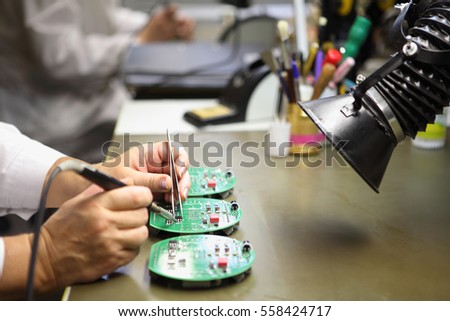 Electronics Manufacturing Services, Manual Assembly Of Circuit Board Soldering,  close-up of the hand women hold tool.