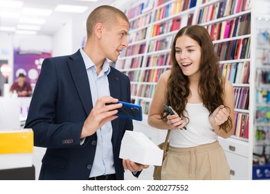 Electronics Store Employee Helping A Woman To Choose A New Smartphone