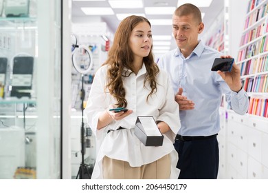 Electronics Store Employee Helping A Woman To Choose A New Smartphone