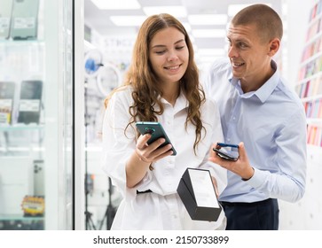 Electronics Store Employee Helping A Woman To Choose A New Smartphone