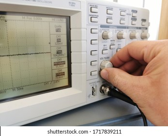 Electronics Technician Adjusts An Oscilloscope To Measure A Frequency