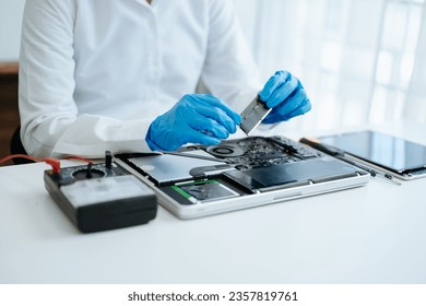 Electronics technician, electronic engineering electronic repair,electronics measuring and testing, repair and maintenance concepts.uses a voltage meter to check and upgrade in shop - Powered by Shutterstock