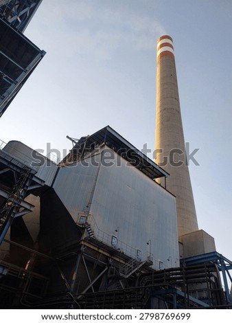 Electrostatic Precipitator (ESP) and industrial stack at a power plant facility, forming an essential part of the emission control system. The ESP is designed to capture and remove particulate matter from flue gases before they are released through the stack, helping improve air quality and support environmental compliance. These large industrial structures represent modern power generation infrastructure and pollution control technology