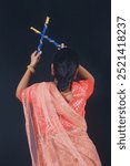 Elegance in Motion: Young Indian Women Ready to Play Dandiya in Traditional Attire, close-up and backside view