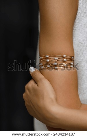 Elegance Personified: Gold Bracelet Adorned with Pearls on a Woman Wrist