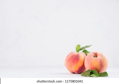 Elegance Ripe Peaches With Green Young Leaves On White Soft Wood Background, Copy Space.