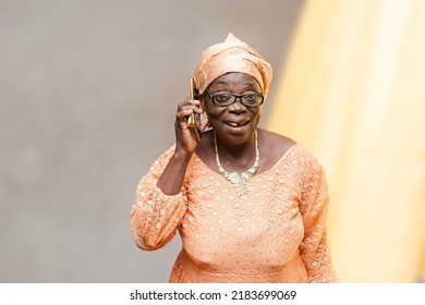 Elegance senior black woman wearing African attire showing excitement receiving phone call - Shutterstock ID 2183699069