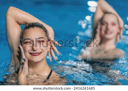 The elegance of a synchronized swimming female duet during training session