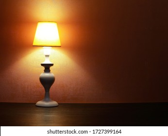 Elegance white desk lamp with yellow lampshade against red wall