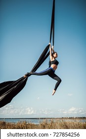 Elegance young beautiful woman dance with aerial silk on a sky background. Fly yoga sport  - Shutterstock ID 727854256