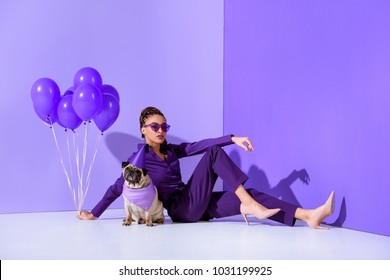 elegant african american girl posing with purple balloons and pug, ultra violet trend 