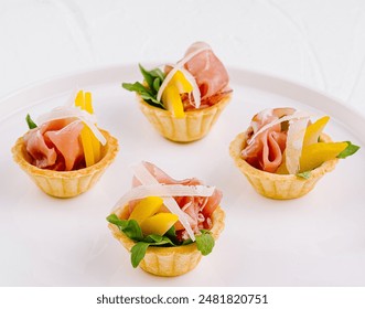 Elegant appetizers with prosciutto, melon, and arugula served on a sleek white dish for fine dining - Powered by Shutterstock