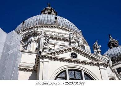 Elegant architectural details of a historic church dome under a clear blue sky in Venice during a sunny afternoon - Powered by Shutterstock