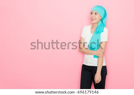 elegant attractive woman cancer patient standing in pink background looking at air daydreaming showing courage to fight disease concept.