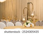 elegant ballroom with banquet tables decorated with warm and charming candlesticks