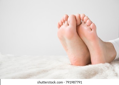 Elegant bare feet. Beautiful groomed woman's feet on the fluffy blanket. Cares about clean and soft legs skin. Lying and enjoying rest. - Shutterstock ID 791987791