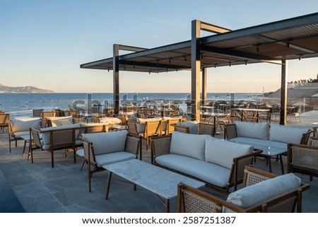 Elegant beachfront dining setup with ocean views, fine glassware, and warm golden hues of the sunset