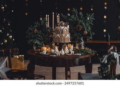 Elegant beautiful Christmas house decoration, stylish holiday decor. Homemade delicious sweet gingerbread house as centrepiece for family dinner. Fir tree branches, candles, stars, garlands - Powered by Shutterstock