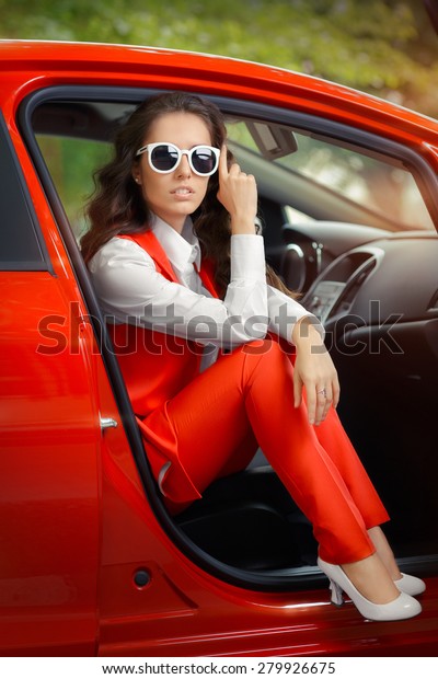 Elegant Beautiful Woman in Red Car\
-Image of a trendy and stylish business woman sitting in a\
car