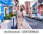 Elegant and beauty african american businesswoman wearing trench coat talking to the mobile phone in the city