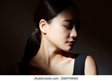 Elegant beauty portrait of a young Asian woman in light and shadow