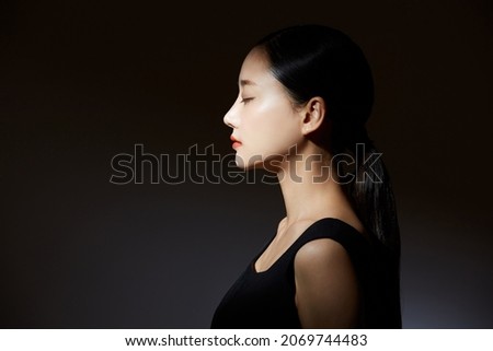 Elegant beauty portrait of a young Asian woman in light and shadow