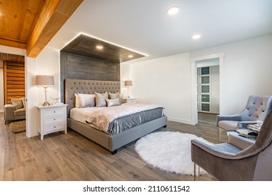 Elegant bedroom in greys soft pastels staged upholstered headboard soft pillows and wooden feature wall - Powered by Shutterstock