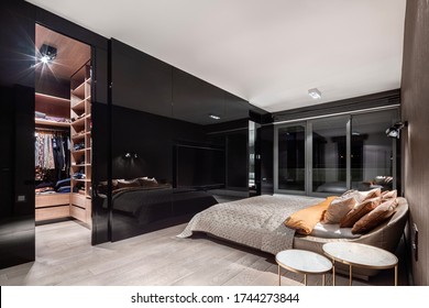 Elegant Bedroom With Walk In Closet Behind Stylish, Black And Mirrored Wall