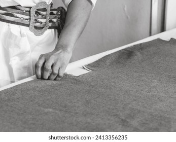 elegant black african seamstress artisan woman measure mark cut sew fabric on a desk in the fashion workshop - Powered by Shutterstock