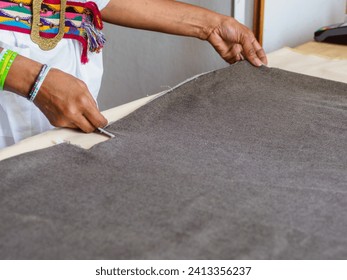 elegant black african seamstress artisan woman measure mark cut sew fabric on a desk in the fashion workshop - Powered by Shutterstock