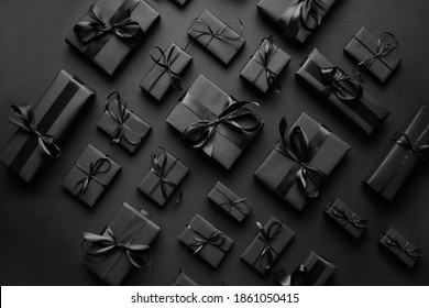 Elegant black Christmas theme. Wrapped gifts in black matte paper with ribbon