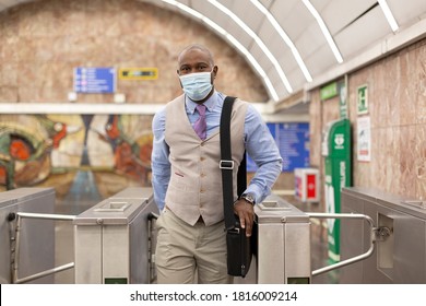 Elegant Black Man Walking Out Of A Subway Station. He Is Wearing A Face Mask. Concept Of Return To Work After Confinement.