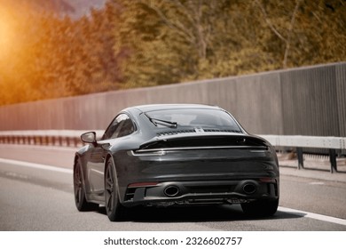 Elegant black modern two-door German roadster. Brand new black luxury carrera sports car on the highway. - Shutterstock ID 2326602757