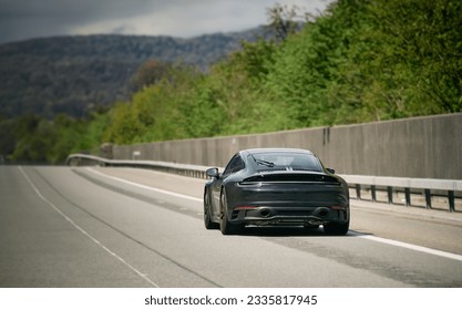 Elegant black modern two-door German roadster. Brand new black luxury carrera sports car on the highway. - Shutterstock ID 2335817945