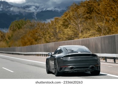 Elegant black modern two-door German roadster. Brand new black luxury carrera sports car on the highway. - Shutterstock ID 2336620263