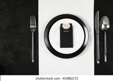 Elegant Black And White Table Setting: Plates On Linen, Blank Label With Rose And Silverware. Top View Point.