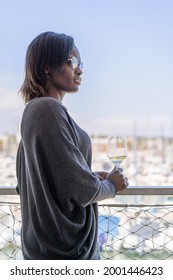 Elegant Black Woman Wearing Sunglasses Relaxing With A Glass Of Wine