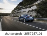 Elegant blue SUV navigating a smooth, open highway surrounded by lush hills, highlighting its modern design, performance, and scenic road trip vibes.