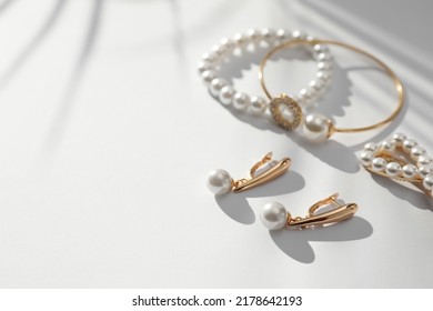 Elegant Bracelets, Hair Clip And Earrings With Pearls On White Table, Closeup. Space For Text