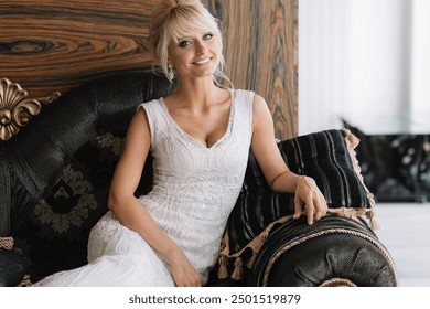 Elegant bride in a beautiful white dress sitting on a stylish sofa in a luxurious interior, smiling and looking happy. - Powered by Shutterstock