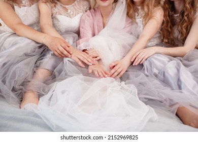 elegant bride with bridesmaids in the wedding morning preparation. Beautiful bride is dressed up an elegant wedding robe, bridesmaids in grey dresses.