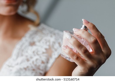 Elegant bride holding in hands a bottle of luxury perfume - Powered by Shutterstock