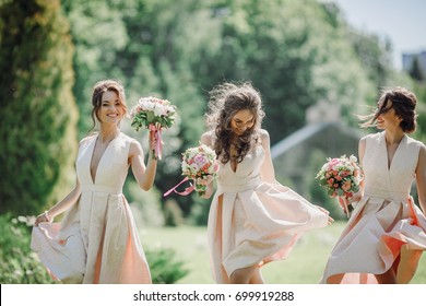 Elegante Brautjungfern gehen auf dem grünen Rasen