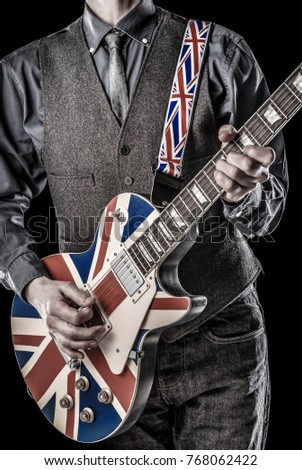 elegant brit pop guitarist playing a british flag guitar