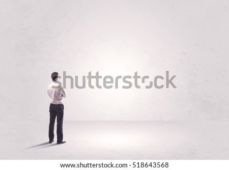 Elegant business person standing with his back looking at big empty white space concept